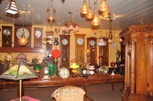 Master clocks from various manufacturers align the wall with more interesting clocks displayed on a long table.