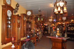 Electro-mechanical clocks line the walls and are illuminated  with antique lighting. 