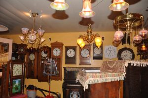 More master clocks with spectacular lighting in the foreground and mechanical musical pieces adjacent to the clocks.