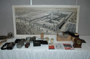 Sangamo timers in front of a large picture of the Sangamo Complex that hung in the main hall at Sangamo in Springfield, Illinois.