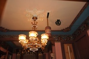 The elegant dining room ceiling is pierced by Seth Thomas tower clock's 9 foot pendulum.