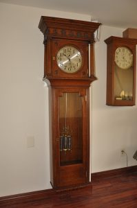 Imperial Clock Company self winding, wall mounted, master clock. Mercurial compensated pendulum, 12 inch silvered dial. American Clock Company self winding clock at right.