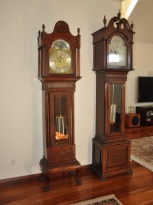 Self Winding Clock Company grandfather clocks. The clock on the left is equipped with a Style C rotary movement and two vibrator movements, one to chime on the quarter hour and the other to strike the hours. The clock on the right is equipped with a Style A rotary movement and has a synchronizer attachment to receive a correction signal. Both clocks have mercury compensated pendulums.