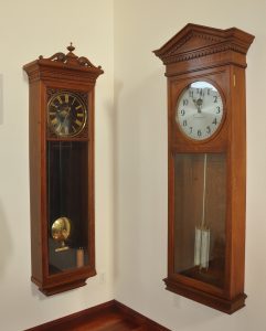 New York Standard Watch Company regulator with glass dial, sweep seconds (left). Self Winding Clock Company #50 regulator, Style F vibrator movement with mercurial compensating pendulum.